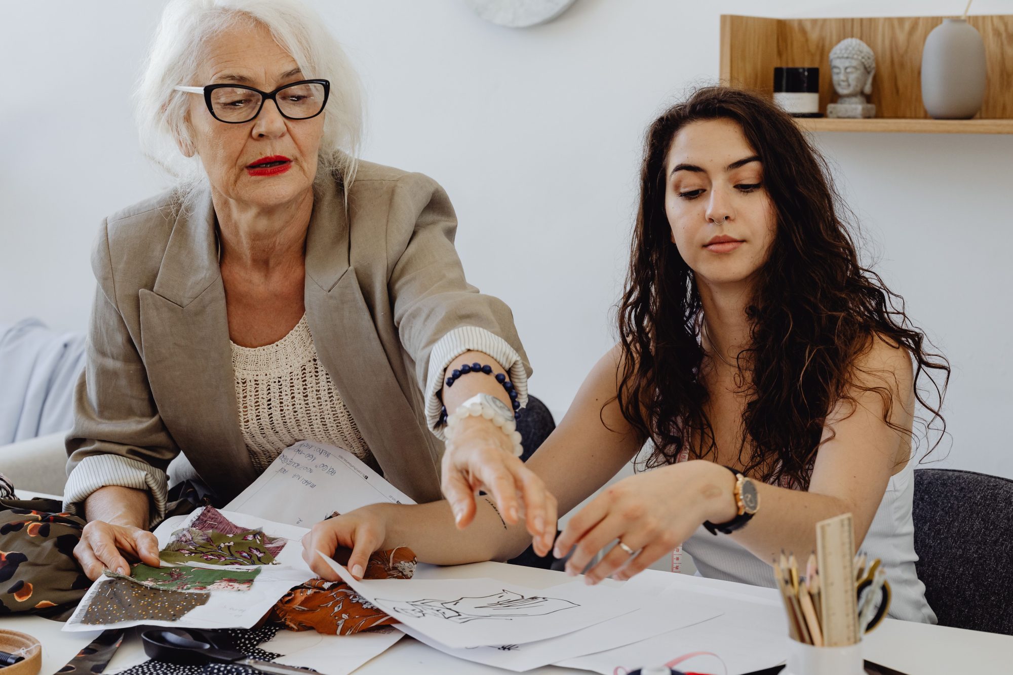 Older and younger women working together at table